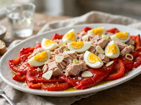 Pimientos asados en tiras con ventresca de bonito y huevo cocido en una fuente